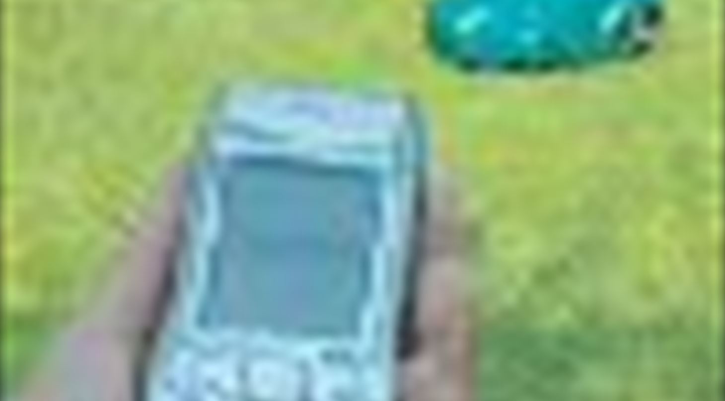 Robotplæneklipper på græsplæne og en hånd der holder en mobiltelefon